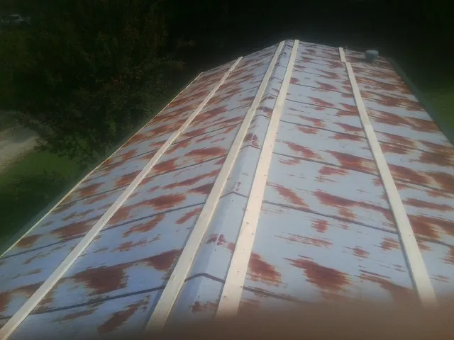 Rusted metal roof panels with new wood purlins before replacement — Storm Damage Roof Repair in Saint Francis by Roofing Brothers